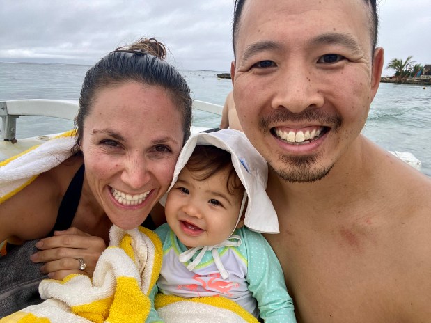 Parents and baby smiling on a boat ride in French Polynesia